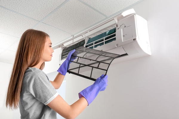 a young female cleaning the air conditioner