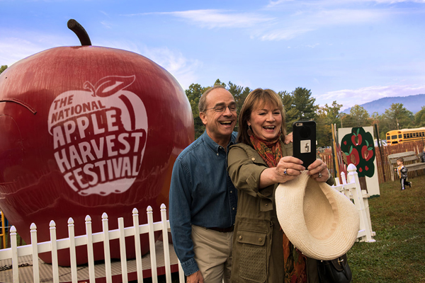 husband and wife taking a selfie in apple harvest festival